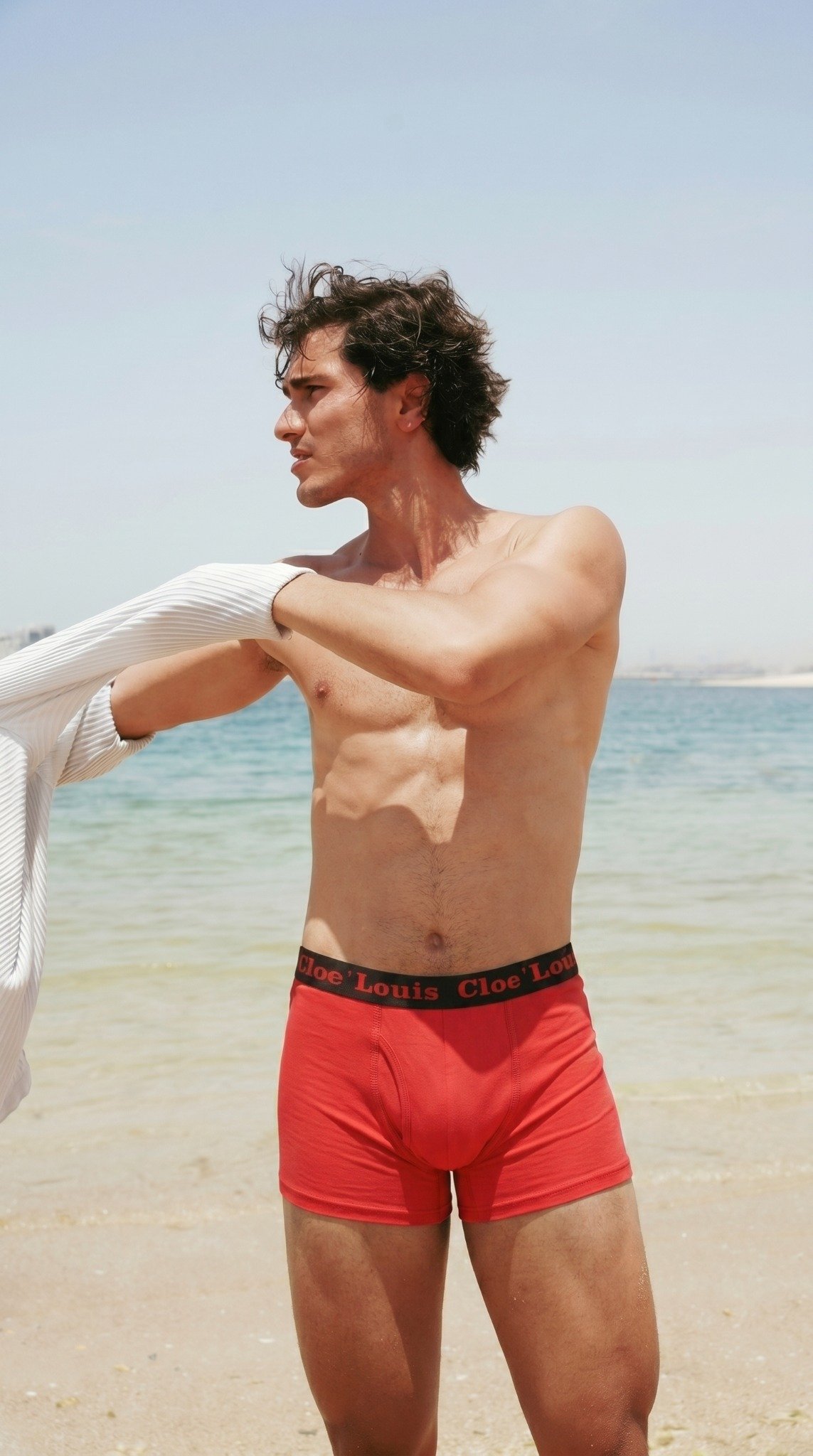 Model wearing red boxer briefs at the beach